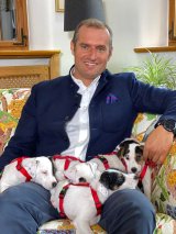 Gut Aiderbichl Geschäftsführer Dieter Ehrengruber mit den 5 entzückenden Hundewelpen, Fotonachweis Gut Aiderbichl