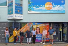 Reiseprofi Harald Schobesberger freut sich mit seinen Mitarbeiterinnen über die Wiedereröffnung seines Reisebüros urlaubswelt.com in Schörfling am Attersee.
